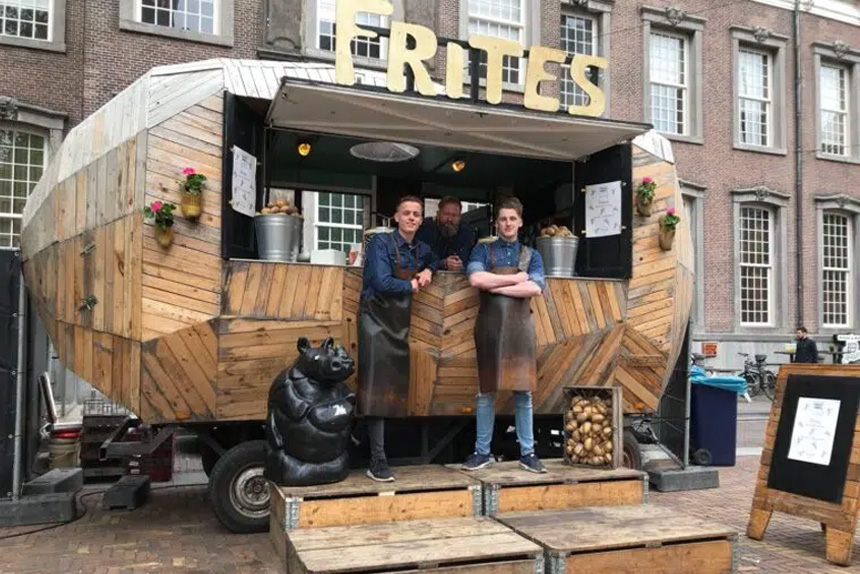 a group of men standing in front of a food truck